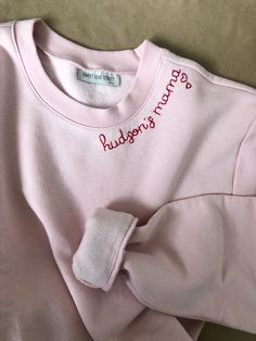 Mamas favorite names hand stitched in red thread on a cozy faded pink sweatshirt. Add a special touch with hearts on the sleeve or collar - one heart for each little one :) Sweatshirts are Unisex sizing and run true to size. I suggest sizing up for a more oversized fit. 70/30 cotton/polyester 3-End fleece, ring spun cotton *Please note that all sweatshirts for this listing are for faded pink long-sleeved crewneck with set-in rib neckband, cuffs & hem band. If you are looking for a specific c Pink Crew Neck Sweater With Ribbed Cuffs, Pink Sweatshirt With Embroidered Logo For Spring, Pink Relaxed Fit Crew Neck Sweater, Pink Winter Sweater With Embroidered Logo, Pink Crew Sweatshirt With Embroidered Graphics, Cute Pink Sweatshirt With Ribbed Cuffs, Pink Long Sleeve Sweater With Embroidered Logo, Pink Crew Neck Sweatshirt With Ribbed Cuffs, Pink Sweatshirt With Ribbed Cuffs And Crew Neck