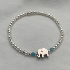 Embodying the sacred symbol of Hindu and Buddhist religions, elephants exude loyalty, power, wisdom, and fertility. Let this bracelet be a daily reminder of these admirable qualities. Create your own of a kind bracelet stack by mixing and matching from our collection! Details: 3mm quality sterling silver beads 7mm x 10mm elephant charm 14kt gold fill & sterling silver beads manufactured in the USA Beaded by hand on durable high performance elastic for a gentle stretch, making it effortless to slide on and off your wrist Pairs seamlessly with any bracelet stack How to figure out your wrist size: To ensure the perfect fit, wrap a flexible measuring tape snuggly around your wrist bone. Note the measurement in inches or centimeters, and then add half an inch for a comfortable fit. (example. if Charm Bead Bracelet, Sacred Symbols, Elephant Charm, Bead Charm Bracelet, Bracelet Sterling Silver, A Daily Reminder, Measuring Tape, Initial Charm, Personalized Necklace