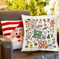 two christmas pillows sitting on top of a brown chair