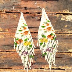 These woven bead earrings  with a beautiful fringe made with white and several other colors of MIYUKI Delica Japanese beads that form a delicate and colorful pattern of flowers throughout the rhombus, using a strong thread to join them together. Add a little elegance and sophistication to your outfit with these beaded earrings. The delicate floral patterns make these stand out, while the texture and colors make them perfect to wear on any occasion. Miyuki Delica's white beads contrast beautifully with the other colors, giving them an amazing look that will complement any outfit. They are very light and easy to carry and are perfect for day to day Please choose the ear hook of your preference, we offer 8 ear hook options to meet your metal sensitivity needs: 1) Nickel free/ Stainless Steel White Beaded Fringe Dangle Earrings, White Bohemian Tassel Earrings For Gift, Bohemian White Tassel Earrings As Gift, Bohemian White Tassel Earrings For Gift, White Bohemian Handwoven Jewelry, Bohemian White Chandelier Earrings For Festivals, White Flower Shaped Beaded Earrings With Colorful Beads, White Dangle Beaded Earrings For Beach, Bohemian White Beaded Fringe Earrings