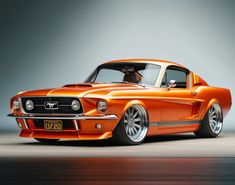 an orange muscle car with chrome rims on the front and sides, parked in a studio