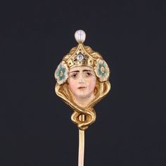 During the turn of the nineteenth century, artisans were inspired by the changing roles of women in society and began depicting the free flowing feminine form in brooches, bracelets, rings and more. This antique stickpin (circa 1890-1900) features a woman of 14k gold, adorned in enamel with a single diamond crown and a pearl accent.  The pin head measures 0.9 inches by 0.5 inches wide with the entire pin measuring 1.9 inches long. It is in very good condition; however there is a chip to the enam Yellow Gold Enamel Brooches, Art Nouveau Cabochon Brooches For Weddings, Art Nouveau Cabochon Wedding Brooches, Gold Formal Enamel Pin, Ceremonial Enamel Brooch Jewelry, Victorian Style Enamel Pin Gift, Ceremonial Gold Art Nouveau Jewelry, Art Nouveau Gold Brooch With Cabochon, Art Nouveau Jewelry With Historical Design For Gift