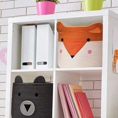 a book shelf with books and other items on it, including an animal - shaped basket