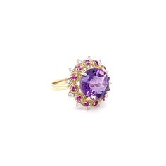 Amethyst, Pink Sapphire, and Diamond Cocktail Ring!  Playful yet Powerful! Its like having a piece of glittery candy on your finger! This ring has a Checkers Round Cut Amethyst that weighs 4.90 Carats and is embellished with alternating 12 Pink Sapphires that weigh 0.28 Carats and 12 Round Cut Diamonds that weigh 0.20 Carats. (Clarity: SI2, Color:F) The total carat weight of the ring is 5.38 Carats.  The ring is crafted in 14 Karat Yellow Gold and weighs approximately 4.8 grams. The ring is a si Fine Jewelry Purple Cluster Rings, Cluster Amethyst Gemstone Rings, Amethyst Cluster Rings With Gemstone, Amethyst Cluster Gemstone Rings, Purple Ruby Ring With Center Stone For Wedding, Elegant Cluster Amethyst Ring, Purple Cluster Rings For Formal Occasions, Elegant Amethyst Cluster Ring, Elegant Purple Cluster Amethyst Ring