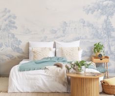 a bedroom with a large wallpapered mural behind the bed and side table in front of it