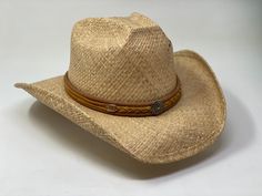 This hat is made from a durable raffia material. It features a square crown and braided leather band. Special shape retention features are designed into each style to help maintain their distinctive shape and form. Shady Brady began producing hats in 1976, with the introduction of their signature Shady Brady California hat. No other hat company distresses and wears in their raffia straw bodies the way Shady Brady does. Their unique designs combine laid back California surf style, urban cowboy, a Country Style Braided Hat With Short Brim, Rodeo Hats With Braided Short Brim, Western Style Short Brim Woven Straw Hat, Adjustable Toquilla Straw Panama Hat For Country Events, Braided Short Brim Hat For Rodeo, Adjustable Toquilla Straw Hat For Country Events, Classic Adjustable Straw Hat, Curved Brim Woven Straw Hat For Ranch, Woven Straw Hat With Curved Brim For Ranch