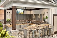 an outdoor kitchen with stone counter tops and bar stools