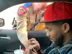 a man sitting in the back seat of a car with a drink and toothbrush