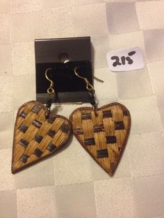 two wooden heart shaped earrings are on display