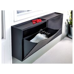 a window sill with an open file holder on the side and two pairs of scissors in it