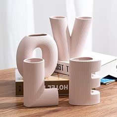 three vases sitting on top of a wooden table next to books and a book