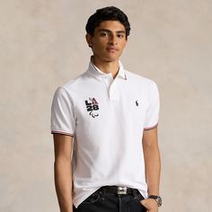 This Custom Slim Fit Polo shirt commemorates the Summer Olympic and Paralympic Games returning to the US in 2028. It’s embroidered with the Paralympic Agitos and an “LA28” graphic inspired by the iconic Ralph Lauren P-Wing symbol from the ’90s marking the first time in Olympic and Paralympic history where the Games emblem is reimagined by Ralph Lauren. White Polo Collar T-shirt With Embroidered Logo, Sporty Short Sleeve Polo Shirt With Embroidered Logo, White Sporty Polo Shirt With Embroidered Logo, Streetwear Polo Collar Top With Embroidered Logo, White Sports Top With Embroidered Logo, White Sports Tops With Embroidered Logo, White Tops With Embroidered Logo For Sports, White Ralph Lauren Polo Collar Shirt, White Ralph Lauren T-shirt With Graphic Print