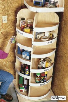 a man kneeling down in front of a pantry shelving unit with labeled shelves on it