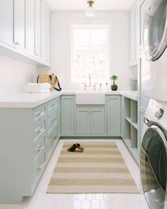 a washer and dryer sitting in a kitchen next to each other on top of a rug