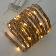 there is a string of lights on top of the roped cord that has been wrapped in twine