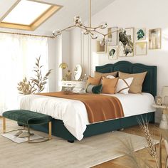 a bedroom with a large bed and pictures on the wall above it, along with a green footstool