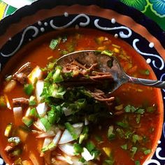 a bowl of soup with meat, onions and cilantro