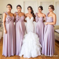 four bridesmaids pose for a photo in their wedding gowns