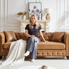 a woman sitting on top of a brown couch