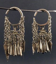 Old Chinese silver earrings, with chains and dangles. Tested as high-grade silver, +800/1000. From the early XXth Century. The earrings measure 9 cm long (3,54 in). The gauge of the silver wire that goes through the earlobe hole is 4 mm. Both of them weigh 87 gr. (SEA202) If sold outside the EU, the buyer is responsible for paying import duties. Shipping: items purchased are ready for shipping in maximum 1-2 days, if not told otherwise. As a regular rule, items under 150 euros are shipped by reg Earrings Asian, Antique Silver Earrings, Ethnic Earrings, Wing Earrings, Silver Work, Earring Crafts, Chinese Antiques, Native American Indians, Earrings Photo