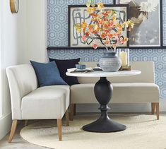 a living room with blue and white wallpaper on the walls next to a round table