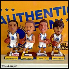 three basketball bobble heads are shown in front of a sign