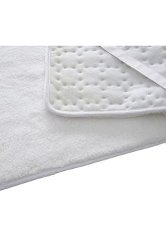 a close up of a white towel on top of a bed with the bottom rolled down