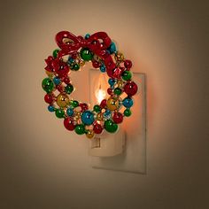 a light that is on the side of a wall with a christmas wreath decoration around it