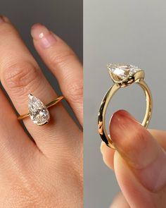 a woman's hand holding an engagement ring with two pear shaped diamonds