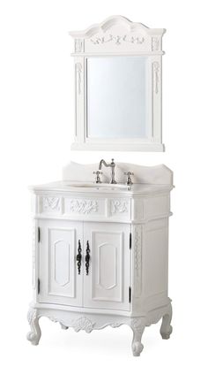 a white bathroom vanity with a mirror above it