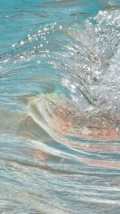 a person riding a surfboard on top of a wave in the ocean with blue water