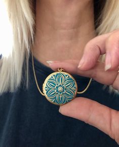 This lovely hand painted blue floral locket is the perfect gift for someone special in your life.  The locket is quite substantial but not so huge it is cumbersome.  This locket works well with family group photos as the photo area is large enough to see the faces of a group.  The locket is made from raw brass and the embossed flower almost takes up the whole front of the locket face.  The locket is strung on a golden brass rolo chain and is finished off with a lobster clasp.  You choose your length of chain at checkout. You can choose to add your own photos to the locket or have us customize it for you with either regular or resin coated photos. This makes a wonderful gift for Mom or Grandma for Mother's Day ,  Something blue for your wedding day, a memorial locket for the loss of a loved Blue Hand Painted Jewelry Gift, Hand Painted Blue Jewelry For Gifts, Blue Hand Painted Jewelry As A Gift, Blue Hand Painted Jewelry For Gift, Blue Hand Painted Round Pendant Jewelry, Blue Medallion Locket Necklace, Personalized Handmade Blue Necklace, Handmade Blue Necklace For Personalized Gift, Hand Painted Turquoise Jewelry Gift