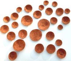 several copper colored bowls are arranged on a white surface