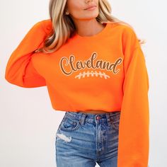 The Cleveland Football Sweatshirt for women is perfect GameDay apparel, offering a stylish way to show team spirit. This sweatshirt makes a great gift for a sport fan and is an ideal outfit idea for tailgate accessories for any girl. ✨ DETAILS ✨ ☆ Gildan 18000 unisex sweatshirt ☆ 50% Cotton (100% ethically grown in the US); 50% polyester ☆ Without side seams: Knit in one piece using tubular knit ☆ Ribbed knit collar with seam: Tightly elastic and retains shape effectively ✨ CARE INSTRUCTOINS ✨ ☆ Machine wash: cold (max 30oC or 90oF) ☆ Use non-chlorine bleach as needed ☆ Tumble dry on low heat ☆ Do not iron ☆ Do not dry clean  ✨ YOU MIGHT ALSO LIKE ✨ 📌 https://www.etsy.com/listing/1636664031/cleveland-football-sweatshirt-gift-for 📌 https://www.etsy.com/listing/1653514695/custom-team-footb Team-colored Fall Sports Sweatshirt, Team-colored Sweatshirt For Sports In Fall, Varsity Crew Top For Fan Gear, Team Spirit Sports T-shirt For Fall, Fall Crew Neck Tops For Sports Events, Orange Sporty Sweatshirt With Graphic Print, Sporty Orange Sweatshirt With Graphic Print, Orange Graphic Print Sporty Sweatshirt, Fall Varsity Sports T-shirt