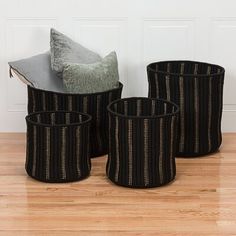 three black baskets sitting on top of a wooden floor