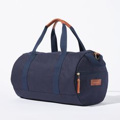 Sporty pals, we’ve had our not-so-sporty-bags stolen just one too many times, so we made you your own. Fabricated of our durable yet lightweight 12 oz canvas and accented with tonal navy webbing this is the perfect grab and go bag. A pair of sneakers, change of clothes, and shower essentials and we’ll have you from the gym to the office in no time. Carry the duffle with the handles or sling it over your shoulder with the removable strap. Casual Cotton Bags For Overnight Trips, Casual Cotton Bag For Overnight Trips, Casual Cotton Duffle Bag For Overnight Trips, Functional Cotton Bag For Overnight Trips, Sporty Cotton Canvas Travel Bag, Casual Canvas Bag For Overnight Trips, Cotton Duffle Bag With Luggage Sleeve For Overnight Trips, Casual Travel Bag With Leather Trim For Overnight Trips, Casual Travel Bag With Leather Handles For Overnight Trips