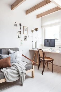 a living room with a couch, desk and computer