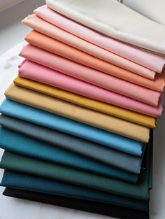 a stack of different colors of fabric