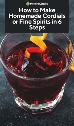 a close up of a drink in a glass with orange peels on the rim