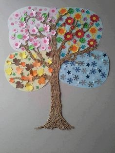 the paper tree is decorated with colorful flowers and leaves, as well as an ornament