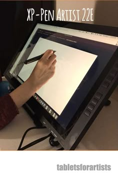 a person writing on a large screen with a pen in their hand and the words xpp - pen artist 22e above it