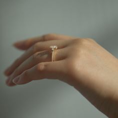 a woman's hand with a diamond ring on it