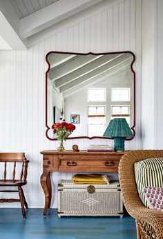 a room with a mirror, chair and table in it