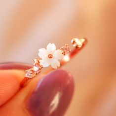 Description: Feel your style flower with our dainty White Flower Ring! Crafted with mother of pearl flower and dainty pink gems, it's sure to bring a twinkle to any outfit. Blooming gorgeous! Ring Details: Material: 18K Rose Gold Vermeil / 18K Gold Vermeil / Sterling silver Anti-allergy and nickel-free. Size: 4-8 Adjustable. Designed in LA In order to extend the life of your jewelry, please remove jewelry before swimming, exercising & bathing. White Flower Ring, Pink Gem, Pearl Flower, Girly Jewelry, Flower Ring, Pretty Jewellery, White Ring, White Flower, 18k Rose Gold