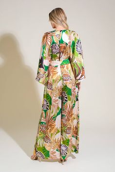 A printed woven jumpsuit featuring V neckline, kimono sleeve, front pleats, wide leg, split back and button zipper closure Details: Self : 97% Polyester 3% Spandex Size & Fit - Model is 5`8" And Wearing Size Small- Measurements Taken From Size Small- Approx. Length: 58" Multicolor Tropical Print V-neck Jumpsuits And Rompers, Long Sleeve Printed Jumpsuits For Beach, Long Sleeve Printed Jumpsuits And Rompers For Beach, Long Sleeve Printed Jumpsuits For The Beach, Printed Long Sleeve Jumpsuits And Rompers For Vacation, Printed Long Sleeve Jumpsuit And Romper For Vacation, Green Tropical Print Jumpsuits And Rompers For Spring, Chic Green Printed Jumpsuits And Rompers, Green Wide-leg Jumpsuits And Rompers For Spring