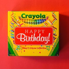 a box of crayon birthday candles on a red background with the words happy birthday