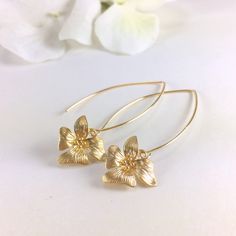 "Gold Orchid Flower Long Dangle Earrings, Floral Drop Earrings, Simple Earrings, Everyday Day Earrings, Wedding Bridal Earrings, Bridesmaid Earrings, Gift for Her Simply and dainty, these earrings are composed of a matte gold/rose gold plated orchid flower dangling from long gold/rose gold tone copper ear wires. Dangle length is 2\" (58mm) from top of ear wire. Flower measures 15x14mm Discount for multiple (3 pair or more) bridal party orders. CUSTOM REQUESTS ARE ALWAYS WELCOMED! ● Would you pre Gold Flower-shaped Hoop Earrings For Wedding, Gold Flower Hoop Earrings For Wedding, Gold Floral Hoop Earrings For Wedding, Gold Hoop Earrings With Flower Charm For Wedding, Delicate Gold Flower-shaped Hoop Earrings, Delicate Gold Hoop Earrings For Party, Dainty Gold Flower Earrings For Anniversary, 14k Gold Filled Flower Earrings As Gift, Delicate Gold Flower Charm Earrings