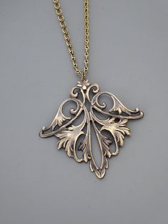 "Vintage Jewelry - Art Nouveau Necklace - Vintage Necklace - Vintage Brass Necklace - French Brass Necklace - Chloe's Vintage Jewelry This is such an exquisite vintage necklace! A gorgeous, graceful floral leaf design. Wonderful warm patina and detail. So very feminine Chloe says, \"Wear it and feel fabulous!\" The pendant measures 2 1/4\" long and 2\" wide. You can choose the necklace length you would like at checkout. Thanks for visiting Chloe's" Art Nouveau Brass Pendant Necklace, Nickel-free Gold Art Nouveau Jewelry, Gold Nickel-free Art Nouveau Jewelry, Ornate Bronze Necklace As Gift, Ornate Bronze Necklace For Gifts, Ornate Bronze Necklace For Gift, Artistic Engraved Bronze Jewelry, Art Nouveau Necklace With Intricate Design For Gift, Art Nouveau Medallion Necklace For Gift