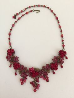 Roses are Red Necklace is so romantic. With several clusters of flowers and a poise of red roses in the center of each. This necklace is a gorgeous stunning red with a hints of green flowers that compliments the red. This piece is set off nicely with pretty red drops hanging off of each cluster. Every one needs a stunning statement red necklace in their collection. Colleen has been creating her unique style of vintage jewelry for more than 30 years. All of our pieces come with an engraved tag wi Red Flower-shaped Necklace With Rose Design, Red Flower Necklace With Rose Design, Red Floral Rose Design Necklace, Red Rose Design Flower Necklace, Red Rose Design Necklace For Wedding, Red Rose Jewelry For Wedding, Elegant Red Jewelry With Flower Decoration, Formal Red Flower Necklace, Dangle Necklaces