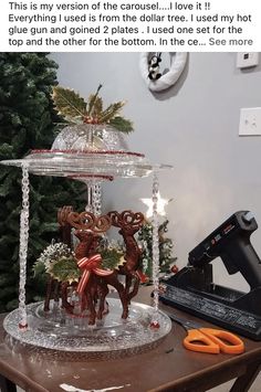 a table topped with a cake covered in frosting and reindeer figurines next to a christmas tree